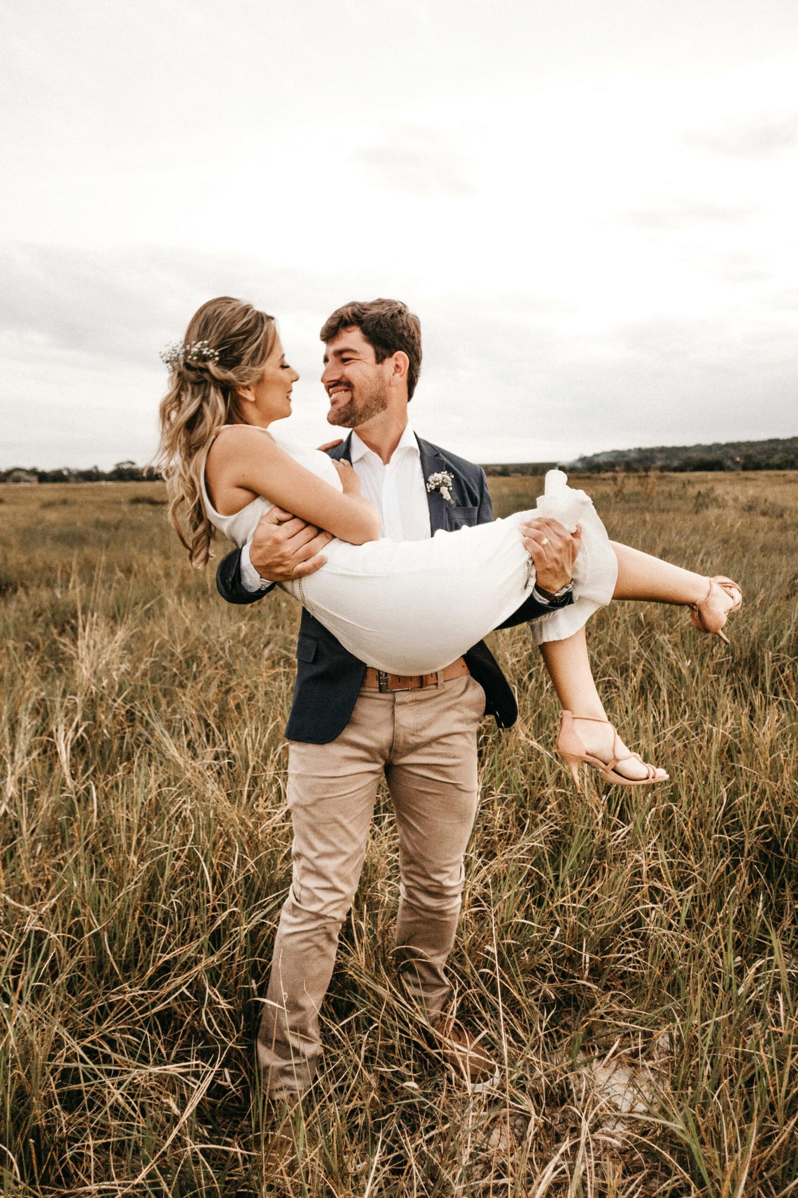A joyful, loving couple in a field, embracing under the summer sun.
